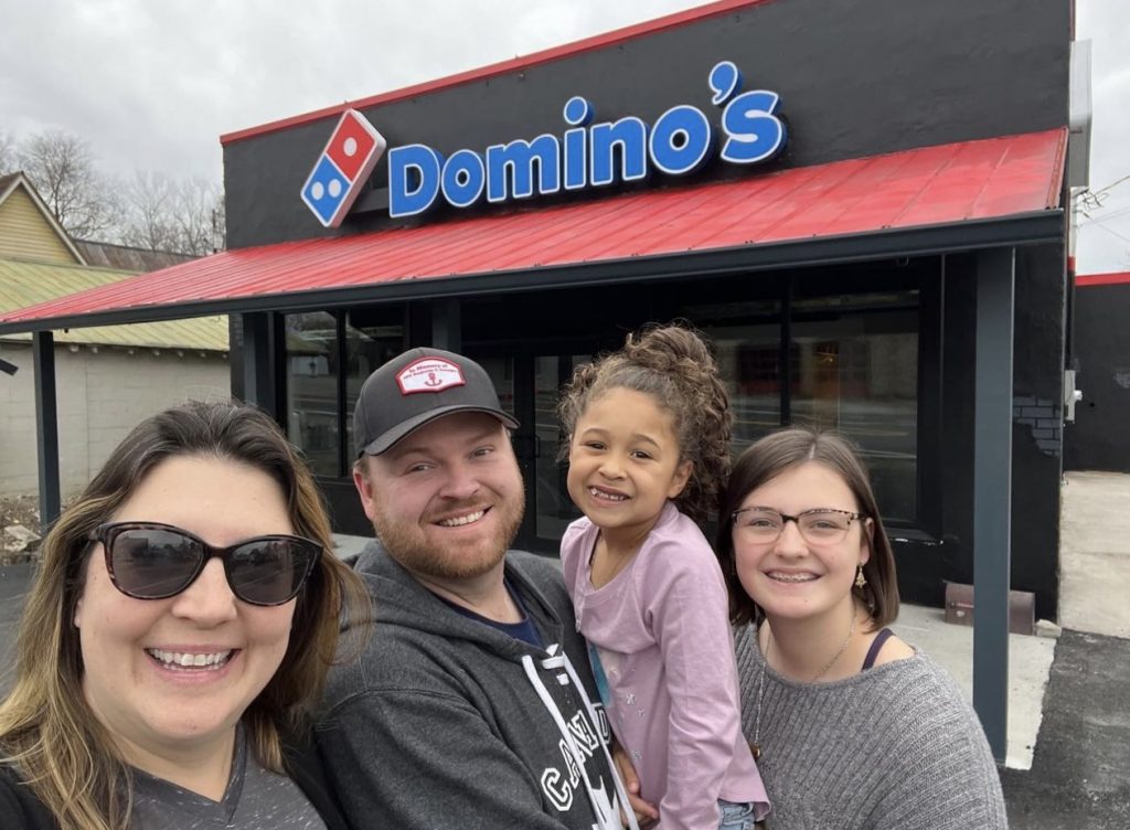 C&W Pizza family outside a Domino's store